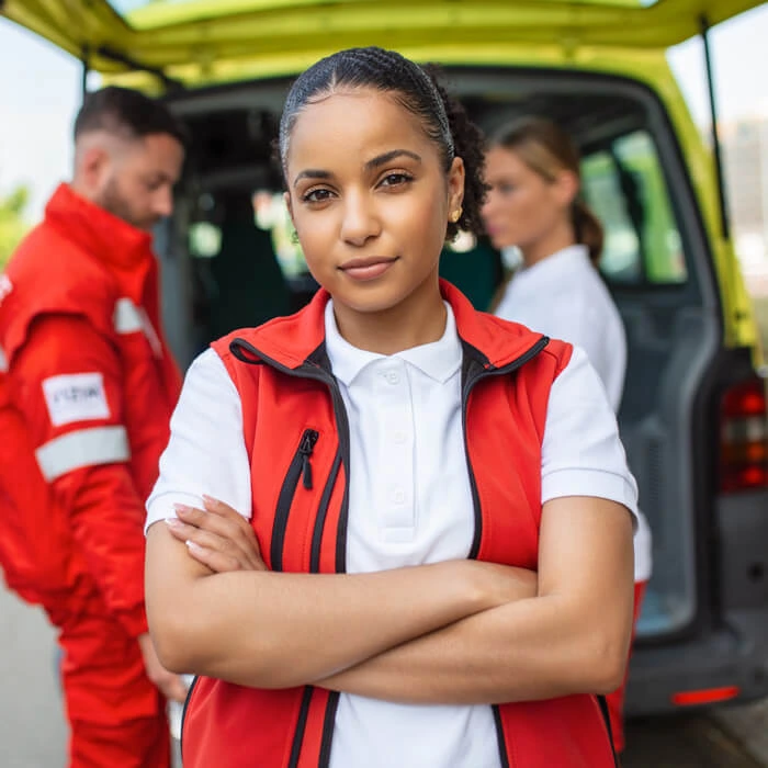 The ambulance crew, a man with a bag on his shoulder and a woman get out of the ambulance